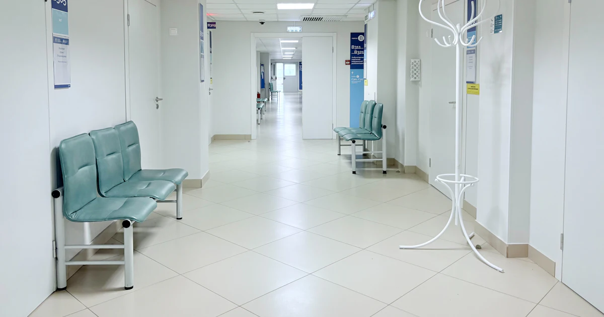 Leerer Krankenhausflur mit Bänken und Türen