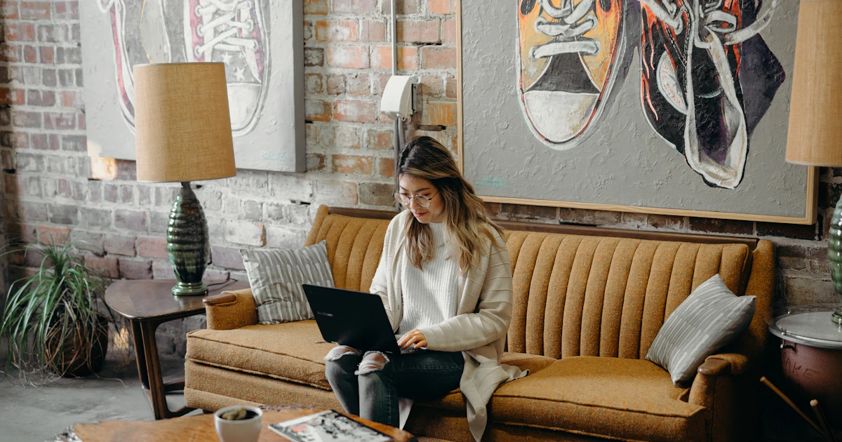 woman using laptop while sitting on chair
