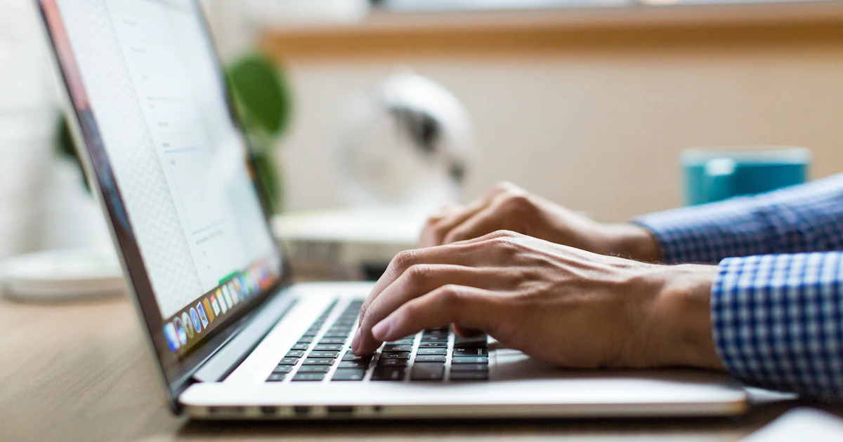 person typing on silver MacBook